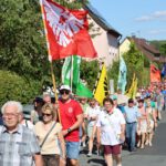 Mit Fahnen und Banner ging es auf den Weg hinauf zum Kreuzberg