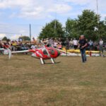 Ein Helikopter fliegt vor den vielen Zuschauern auf dem Flugfeld