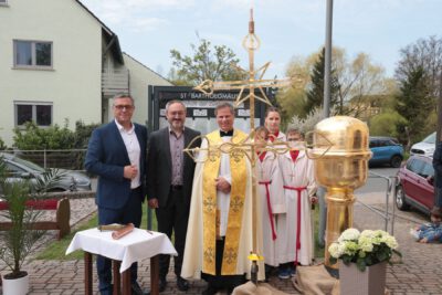 Gruppenbild mit Pfarrer Matthias Steffel, Bürgermeister Gerhard Bauer und Kirchepfleger Marius Birkner vor der Installation des Turmkreuzes